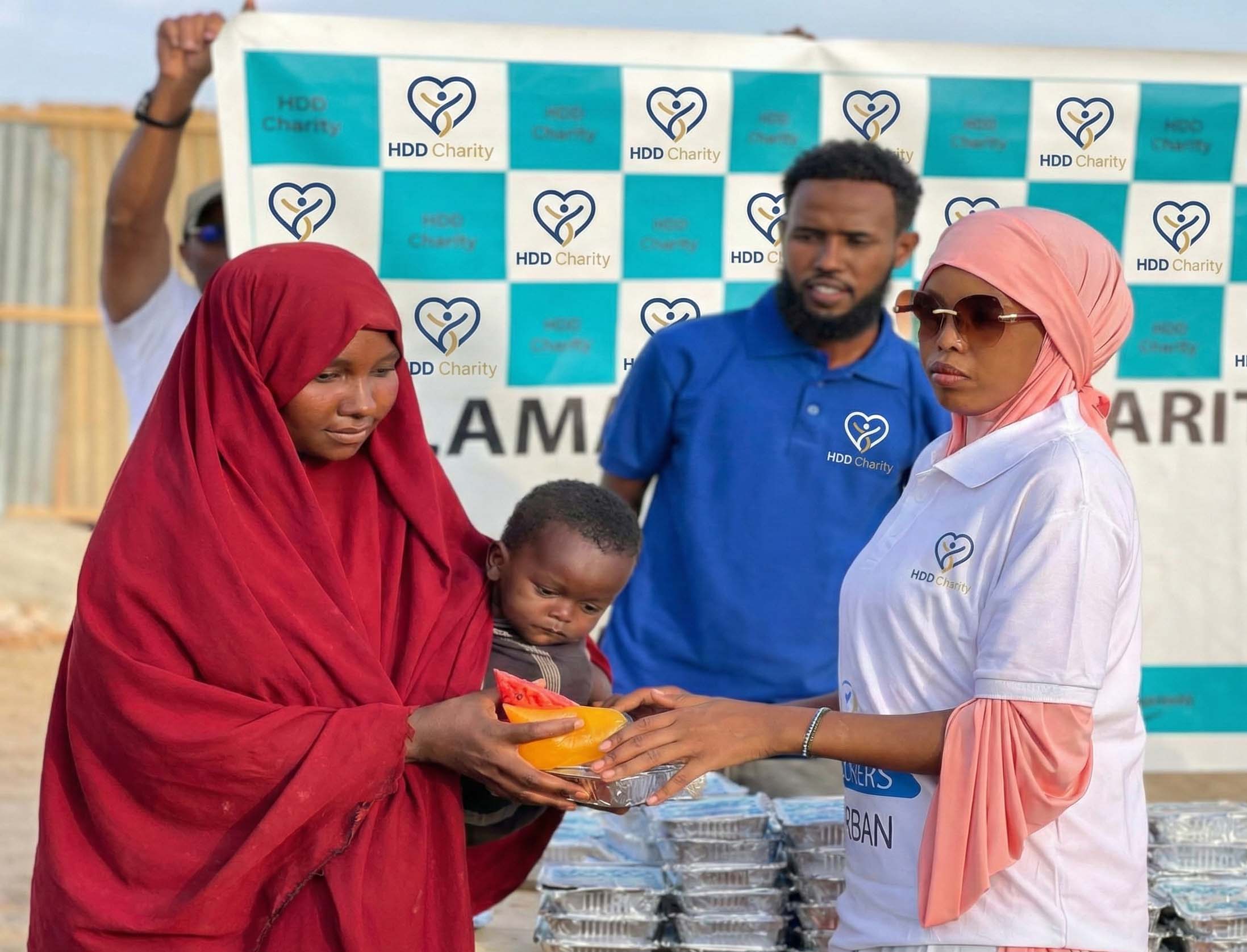 HDD Charity Helferin übergibt Ramadan-Paket an somalische Mutter mit Kind